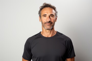 Fototapeta premium Portrait of a tender man in his 40s wearing a moisture-wicking running shirt while standing against white background