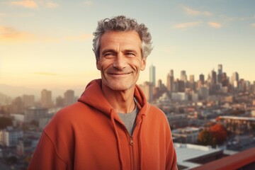 Portrait of a smiling man in his 50s dressed in a comfy fleece pullover isolated on vibrant city...