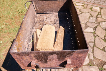 Iron grill and firewood for barbeque inside. Selective focus