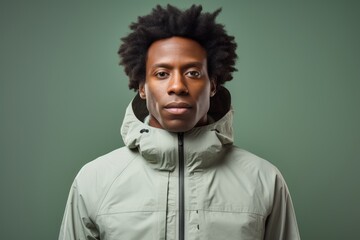 Portrait of a content afro-american man in his 30s wearing a windproof softshell in front of modern minimalist interior