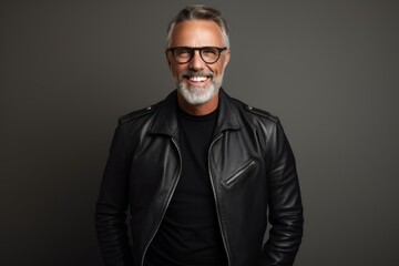 Obraz premium Portrait of a happy man in his 50s sporting a classic leather jacket on modern minimalist interior