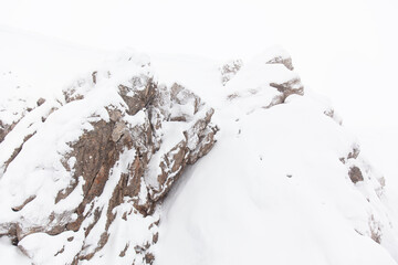 Red rock covered with snow. Felsgestein im Schnee. Roter Felsen mit Schnee bedeckt. Natural stone in the snow.