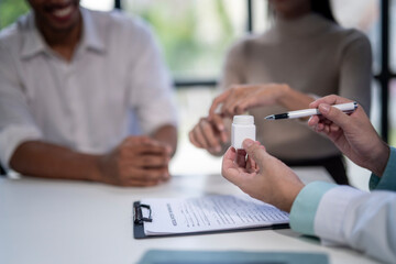 A doctor is holding a white pill bottle and a pen