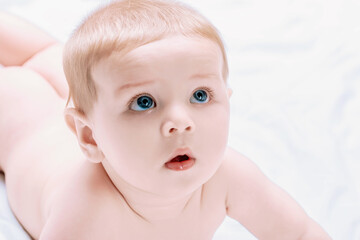 Curious baby lying on stomach and looking up