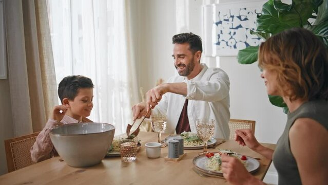 Loving family eating lunch at kitchen closeup. Parents child at dinning room