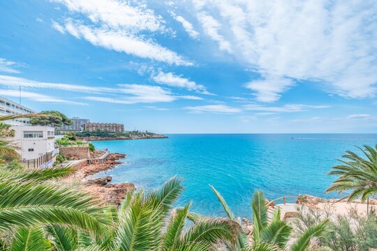 View of part of the promenade that connects the beaches of the city of Salou with the arrival of tourists Sea and palm trees in the tourist town of Costa Dorada