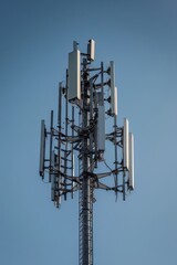 A Tall Cellular Tower Against A Clear Blue Sky