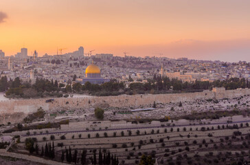 Fototapeta premium The panorama scenic view over the Dome of Rock Muslim temple and the Al-Aqsa mosque, the Muslim shrines, on the Temple Mount in the Old City of Jerusalem, during the sunset in Israel. 