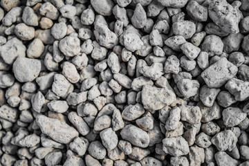 A spread of small white pumice stones. These stones are used as a growing medium for ornamental plants, especially cacti and bonsai.