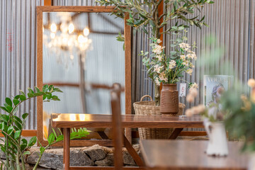 The background of the park decoration has a corner table and wooden chairs for sitting and relaxing during the day. Amidst the various flowers, the beauty of the green grass.