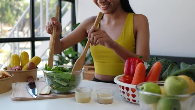 Young chef in a modern kitchen prepares a fresh salad with vibrant vegetables, showcasing healthy meal preparation and culinary skills