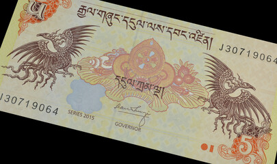 5 Ngultrum banknote printed by Bhutan, that shows Dharma Chakra with DeyNga and Bja Tshering, a mythical bird that brings about long life