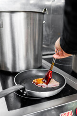 Person cooking tuna in a frying pan on a stove