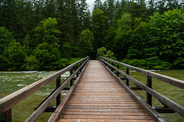 Obraz premium Holzbrücke über der Traun und das beeindruckende Bergpanorama in Obertraun, bei Hallstatt, Salzkammergut, Oberösterreich
