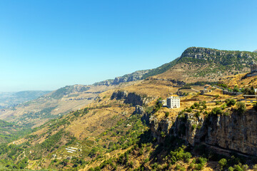 Fototapeta premium Aerial view of valley between mountains and houses on a cliff. Republic of Lebanon