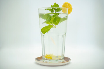 A glass of Mint Lemonade Water in it  with Green leaves Isolated Cold Lemon Gin Tonic 