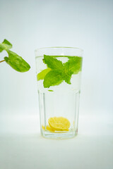 A glass of Mint Lemonade Water in it  with Green leaves Isolated Cold Lemon Gin Tonic 
