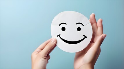 happy smiling face made by paper holding in hand,Hand holding paper cut smile face, positive thinking, mental health assessment , world mental health day concept