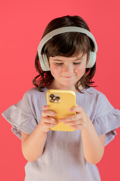 Young girl using smartphone and headphones in studio