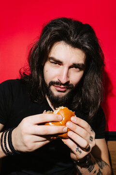 Man enjoying a juicy burger at a vibrant barbecue restaurant