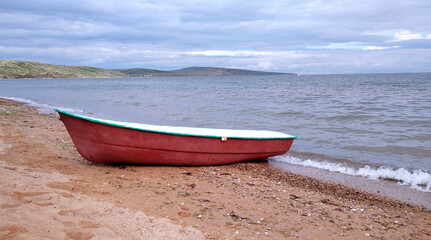 Fototapeta premium Crimea. Kerch Peninsula. Red boat on the shore of the Azov Sea.