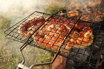 Coil of spicy beef sausage grilling on a fire. Delicious grilled sausage. Spirals sausage grilling on a BBQ