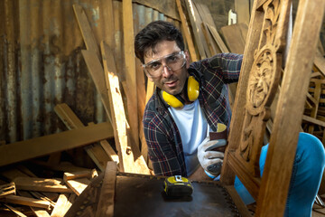 Caucasian carpenter man sanding diy woodchair in carpentry woodwork