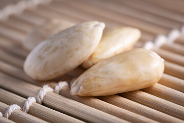 Several almonds on a wooden background with soft lighting, selective focus.