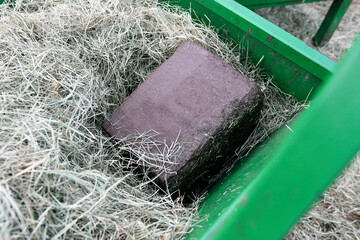 Close up of a trace mineral salt block for livestock in a hay feeder