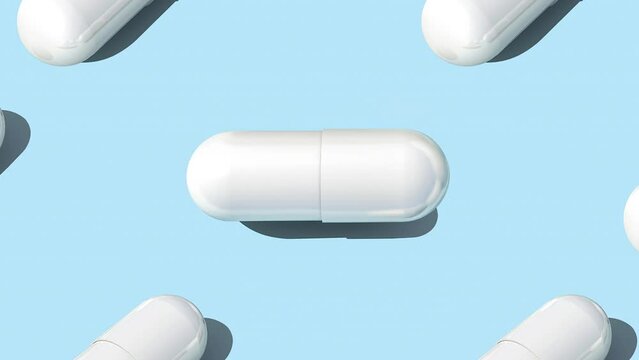 White capsule pills on blue background , Medicine concept. Pattern with capsule pills slow motion 4k video.