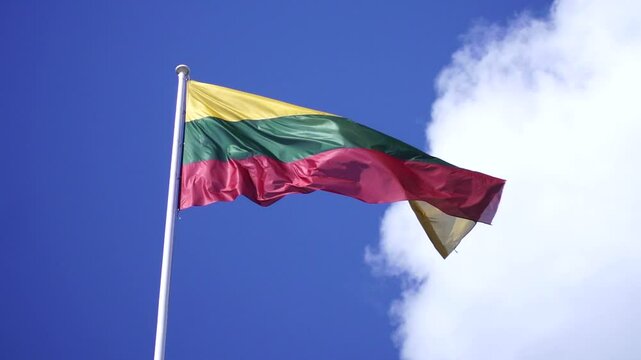 National flag of the Republic of Lithuania waving against blue sky on a sunny day
