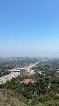 Views of the freeway from the Getty Center. The Angels. Busy highway traffic at sunset with view of nearby hills.