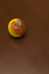 A red rotten apple. Spoiled fruit. The concept of death.