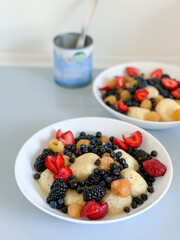Breakfast with berries in a white plate on a white table