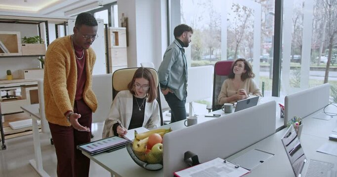 A group of multicultural business coworkers showcase teamwork in action, engaging in various office activities and creating a dynamic work environment.