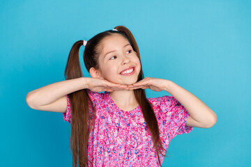Photo of charming positive small girl wear pink dress arm chin looking empty space isolated blue...