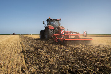 Fototapeta premium Tractor preparing land with seedbed cultivator.