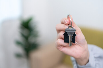 A real estate agent handing over the keys and signing the contract for a new home to a smiling young couple The couple was happy to buy a home and own a new home.