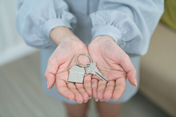 A real estate agent handing over the keys and signing the contract for a new home to a smiling young couple The couple was happy to buy a home and own a new home.
