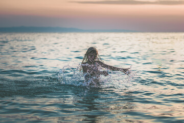 girl splashing in the sea, summer vibes, happiness and joy