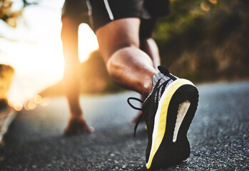 Person, legs and running start with shoes in street for morning workout, race or outdoor exercise....