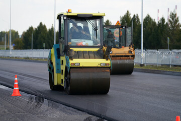 Reconstruction of a highway. Two road rollers compact the laid asphalt concrete.