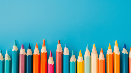 Row of multi-colored pencils on a pink, blue, red and yellow backgrounds