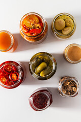food, eating and preserve concept - close up of jars with preserves on white background, top view
