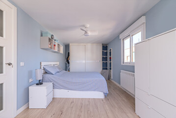 Bedroom with white furniture, matching wardrobes and blue painted walls
