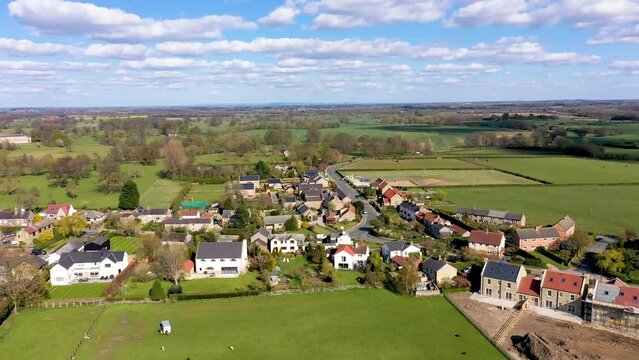 Aerial footage across the beautiful small town of Little Ribston in the Harrogate district of North Yorkshire, England showing the classic village and country side in the Spring time