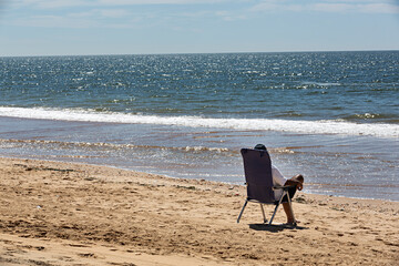 Hombre sentado en la playa mirando el mar.