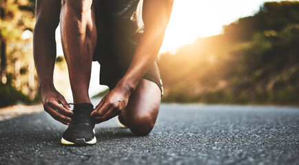 Person, closeup and tying shoes with hands in street for running, morning workout or outdoor...