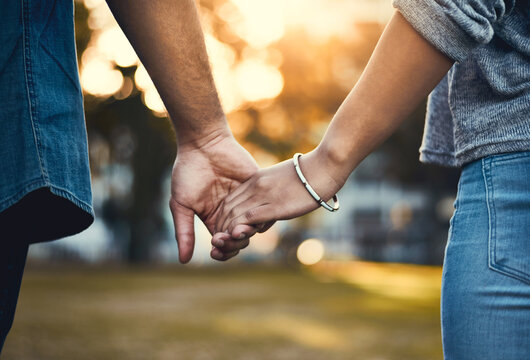 Couple, back and holding hands outdoor for love, relationship and date together with loyalty. Man, woman and commitment as romantic walking with trust, support and care in street for happiness