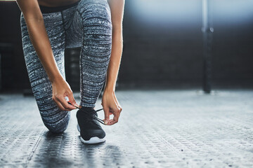 Woman, hands and shoe laces in gym for fitness, floor and strength or cardio workout. Sport,...